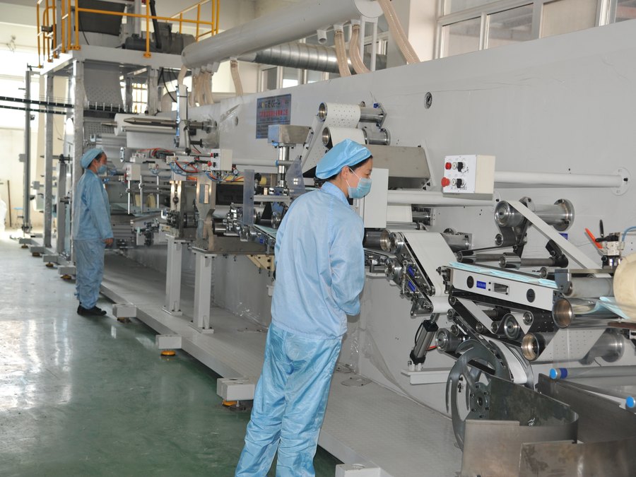 Operators running the packing machine in sterile gowns